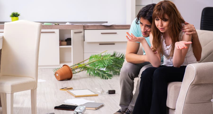 Young couple sitting inside house after a burglary